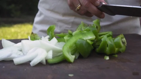 Woman's hand adding cut-up vegetables to a pan Vídeos de archivo 116751471