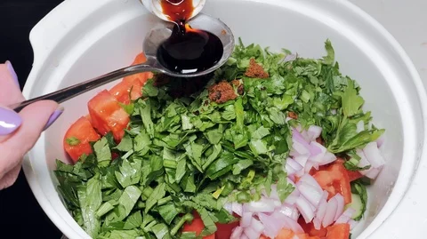 Woman's hand adding soy sauce to vegetable salad in bowl, healthy fresh diet Stock Footage 89737637