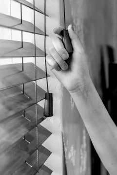 Woman's hand and blinds Stock Photos