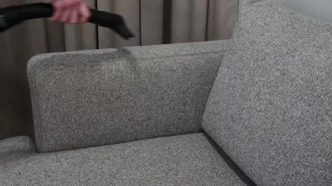Woman's Hand are Cleaning Gray Sofa with a Modern Vacuum Cleaner. Stock Footage 147008155