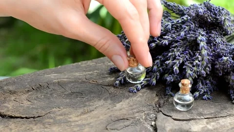 A woman's hand arranges bottles with lavender essential oil Stock Footage 157724085