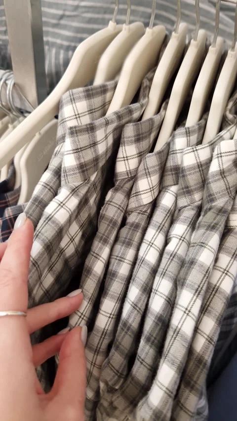 Womans Hand Browsing Plaid Flannel Shirts on a Rack Stock Footage 326061557