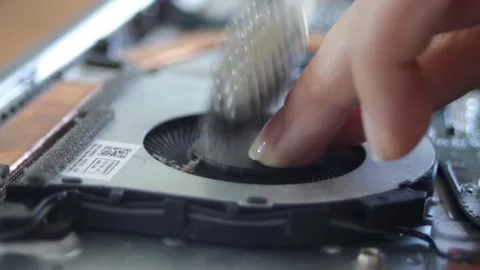 A woman's hand brushes the dust off the computer fan with light movements Stock Footage 297071332