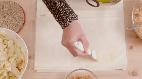 Woman's hand brushing pie crust with melted butter shot from above Stock Footage 121296480