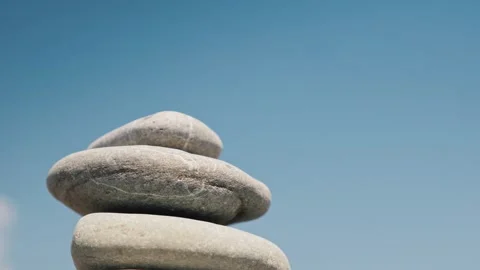 Womans hand building zen stone tower against clear blue sky during sunny da.. 스톡 동영상 334827508
