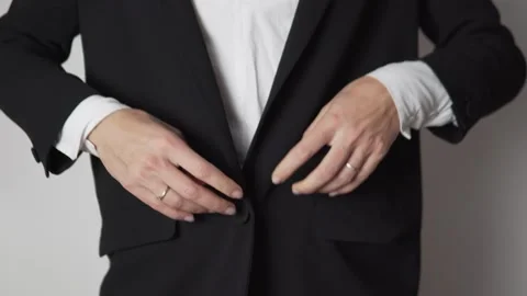 A woman's hand buttons a button on the jacket and straightens the work uniform Stock Footage 143161026