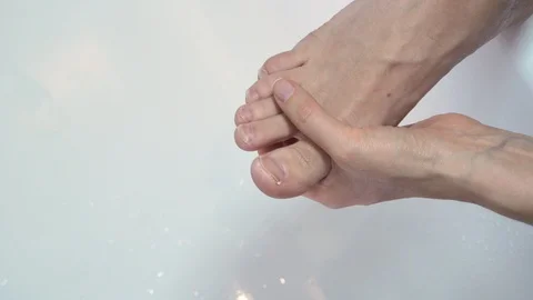 A woman's hand can cut man's nails. Scissors cut off large toenails. Stock Footage 99728984