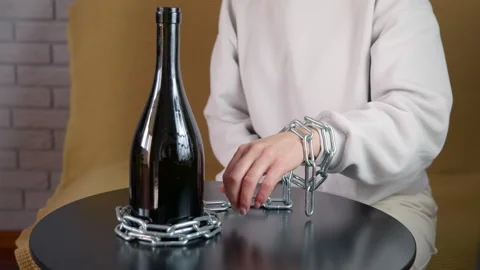 Woman's hand chained to a bottle of alcohol Stock Footage 345397489