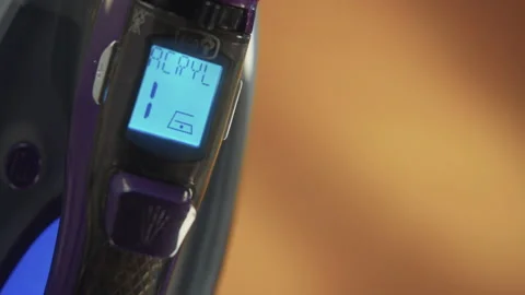 A woman's hand that changes the heat setting of the iron Stock Footage 171643896