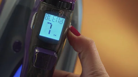 A woman's hand that changes the heat setting of the iron Stock Footage 171688308