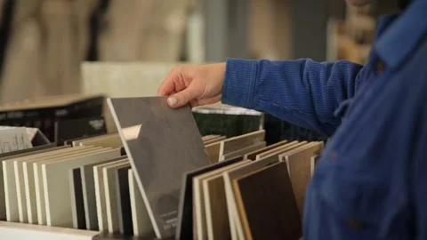 A woman's hand choosing a ceramic tile from samples in a ceramic tile store. Stock Footage 301166225