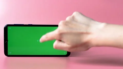 A woman's hand clicks on the green screen of the smartphone Stock Footage 155516695