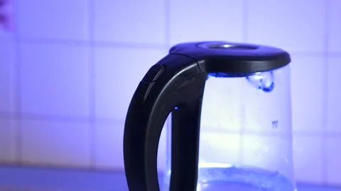A woman's hand in close-up puts an electric kettle in the kitchen Stock Footage 256606580