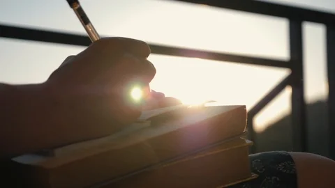 Woman's hand close-up, writing a note or letter to a notebook with a pen on a Vidéo 94921417