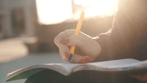 Woman's hand close-up, writing a note or letter to a notebook with a pen on a Stock Footage 111368012