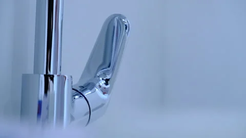 Woman's hand closes chrome plated water Stock Footage 137310979