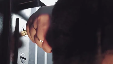 A woman's hand closes the door, inserts the key into the keyhole, turns and Stock Footage 151420296