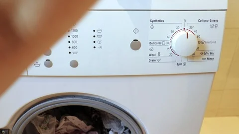 Woman's hand closes a washing macine and switch on a washing program and pushes Video stock 101201530