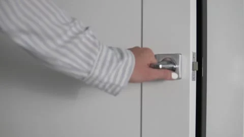 Woman's hand closes white door behind doorknob Stock Footage 130921975