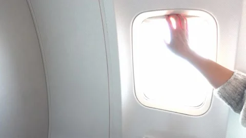 Woman's hand closing an airplane window Stock Footage 136773878