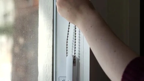 Woman's hand closing window blinds slowly Stock Footage 329184832