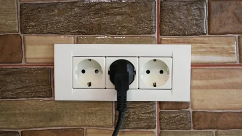 Woman's hand connecting a device in a triple power wall socket, middle 動画素材 141169542