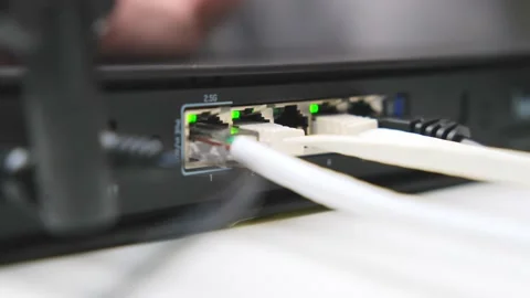 Woman's hand connects internet cable to LAN wired network switch. Stock Footage 232772570