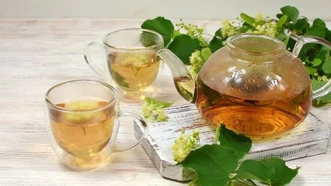 A woman's hand covers the teapot, where tea is brewed in a glass teapot against Stock Footage 169170086