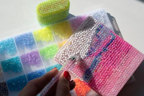 A woman's hand creating a bedazzled design with sparkling rhinestones Foto stock