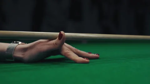 A woman's hand with cue aiming on billiard ball at green table Stock-Footage 240239889