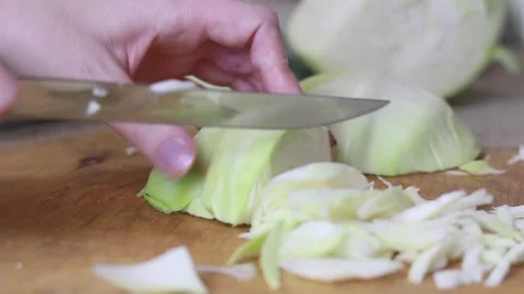 A woman's hand cuts the cabbage with a knife. Cooking food, close-up Stock Footage 151752507