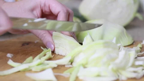 A woman's hand cuts the cabbage with a knife. Cooking food, close-up Stock Footage 152043993