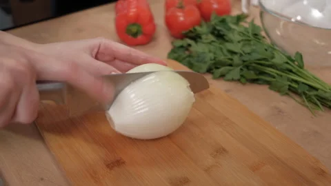 A womans hand cuts a large onion on a board.Fresh vegetables, healthy food Stock Footage 262431784