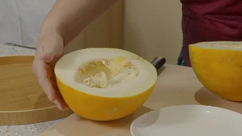 Woman's hand cuts a melon  and removes the seeds Stock Footage 287606447