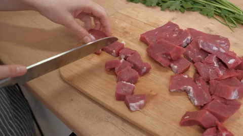 A woman's hand cuts raw red beef meat. Preparing ingredients for a healthy diet Stock Footage 262440405