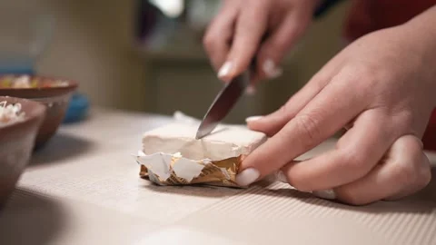 A woman's hand cuts yeast with a knife for making dough Stock Footage 253486646