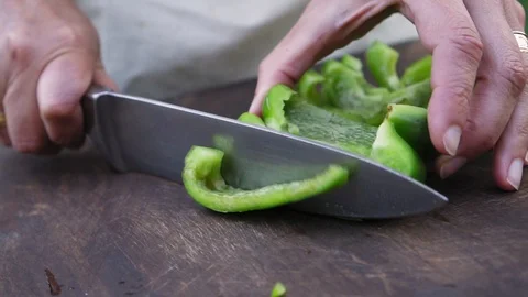 Woman's hand cutting a bell pepper in slow motion Vídeos de archivo 116750690