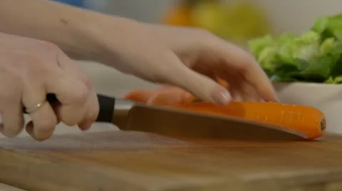 Woman's hand cutting carrots in kitchen Stock Footage 22059184