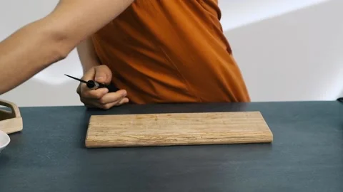 Woman's hand cutting a lemon. Hand holding a lemon and cutting a half of it with Video stock 132909041