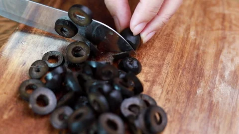Woman's Hand Cutting Olive With Knife On Cutting Board Stock Footage 160156744