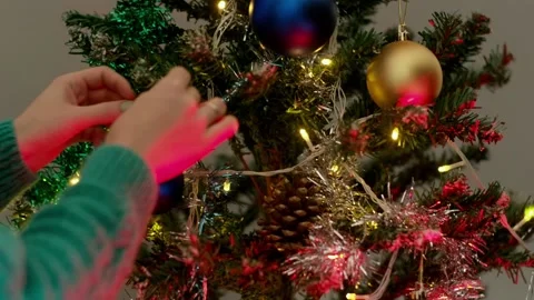 Woman's hand decorating Christmas tree with colorful balls. Stock Footage 166317475