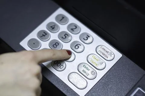 A woman's hand dials a pin code on an ATM 写真素材