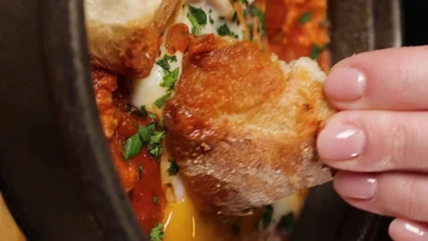 A woman's hand dips a piece of bread Stock Footage 263730102