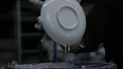 A woman's hand dips a small plate into the icing. Side view. Video stock 130526236