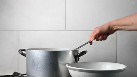 Woman's hand drains the noodles with a fork after cooking. Stock Footage 146328234