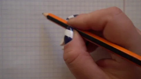 Woman's hand draws a smiley face with a pencil in a notebook Video stock 76213053