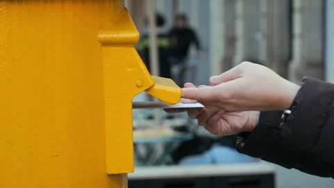 A womans hand drops a postcard into a mailbox. A person sends an envelope with Vidéo 326903795