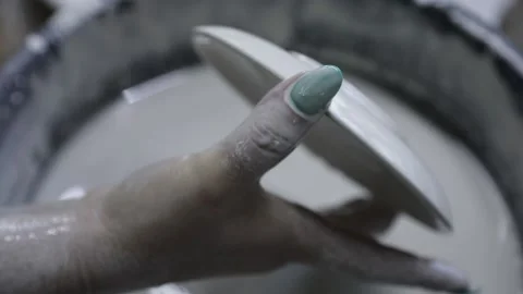 A woman's hand drops a small plate into a bowl of icing. Video stock 130526238