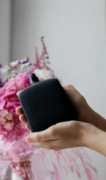 A woman's hand elegantly holds a class perfume bottle Foto stock