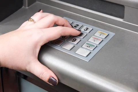 Woman's hand entering pin code on atm machine Stock Photos
